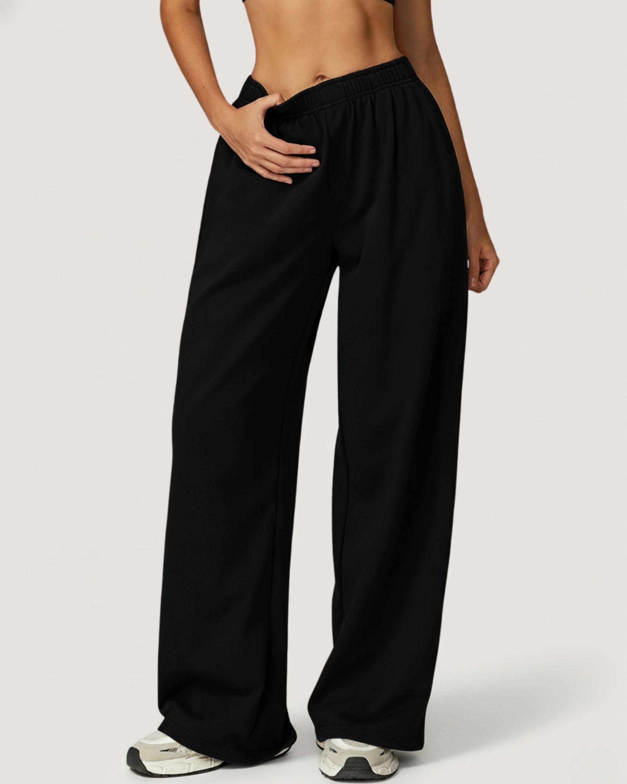 Schwarze Premium High-Waist Wide Leg Hose für Damen, Vorderansicht am Model, getragen als elegantes Sport-Set mit passender Jacke, locker fallendes weites Bein - Ryze.