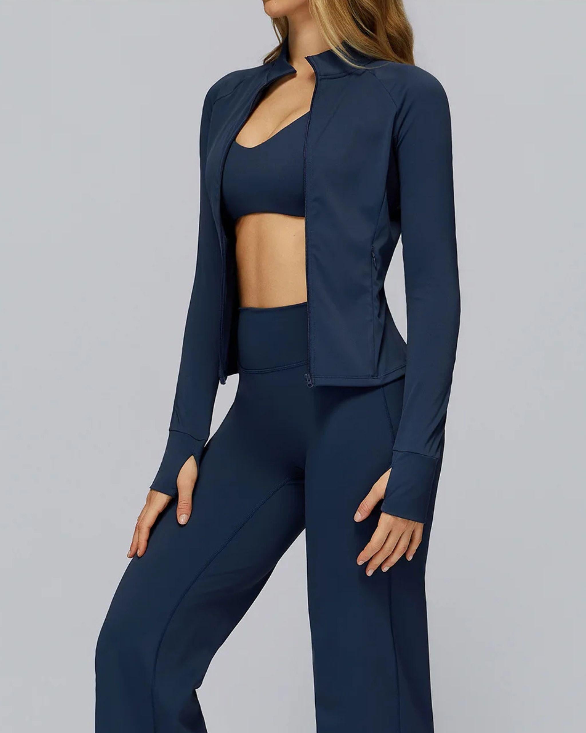 Marineblaue Damen Trainingsjacke mit Reißverschluss, seitliche Pose, enganliegende Passform (Slim-Fit), lange Ärmel mit Daumenlöchern - Ryze.