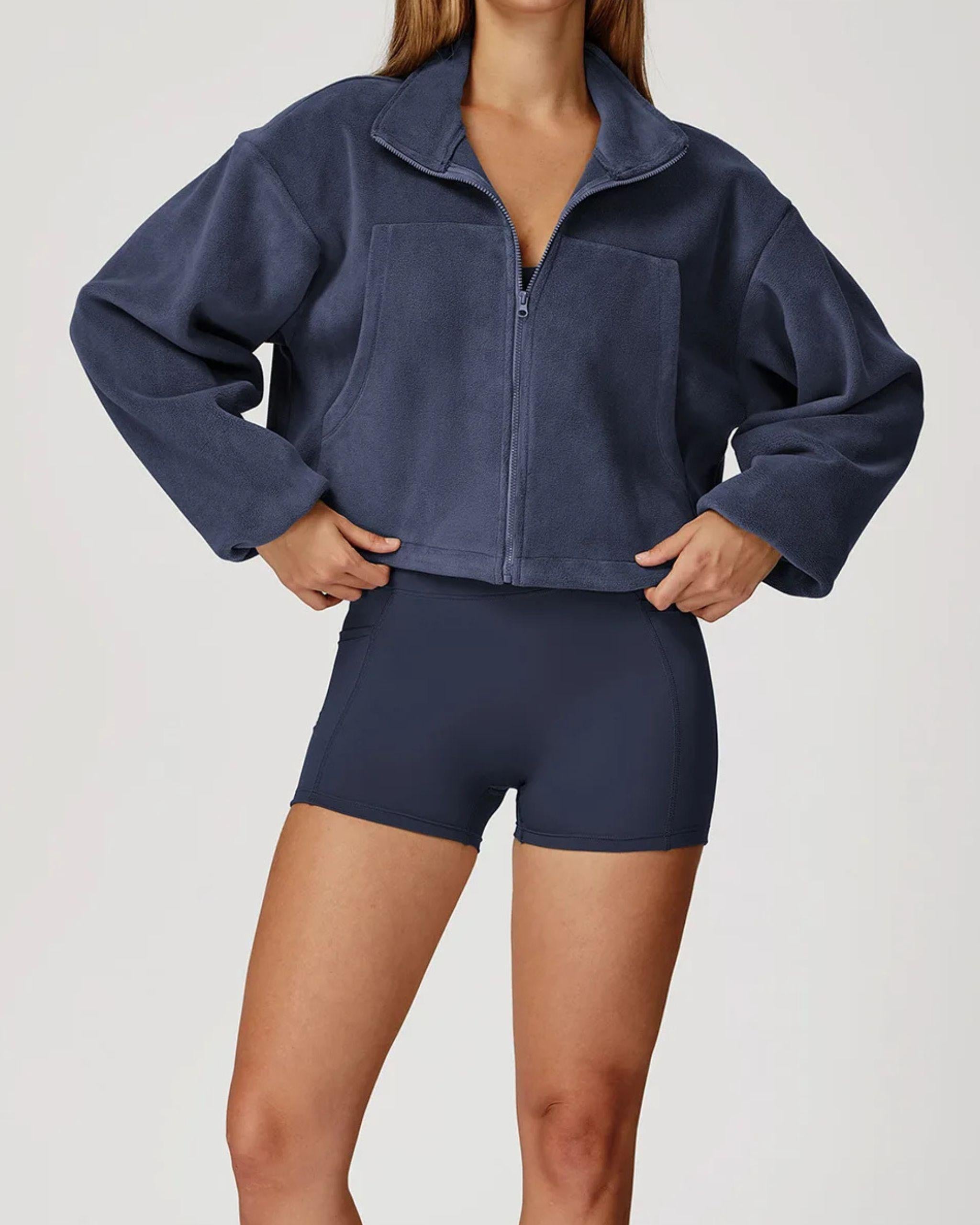 Fleece Jacke Kurzgeschnitten Marineblau mit Reißverschluss Vorderansicht für Cool Down und Athleisure Stil.