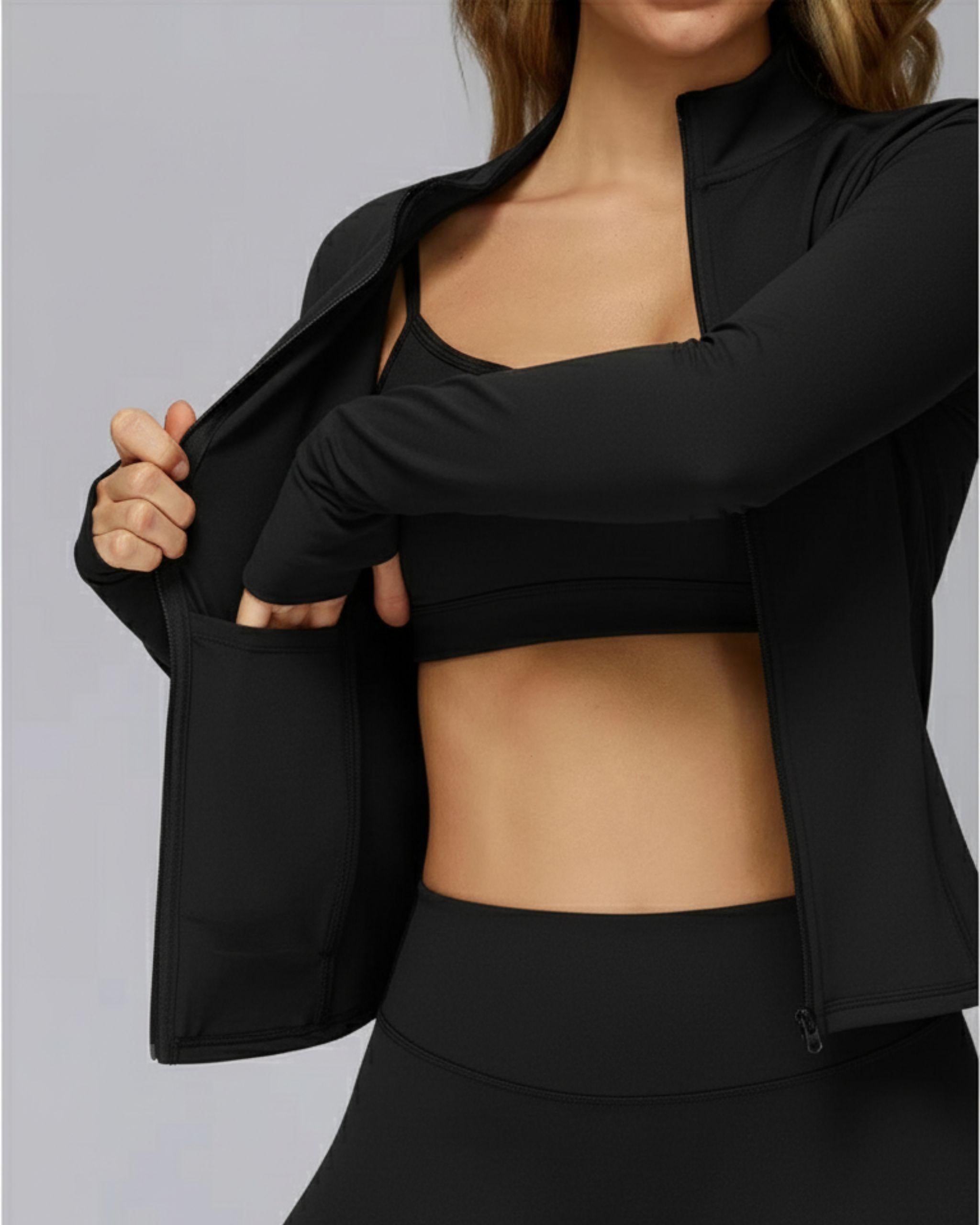 Nahaufnahme der schwarzen Sportjacke, Detail der seitlichen Eingrifftasche, Hand zeigt die Funktionalität, weiches Stretch-Material - Ryze.